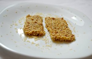 sezam a med - snacky nakrájané na obdlžníky na tanieriku ozdobené lúpanými semiačkami sezamu